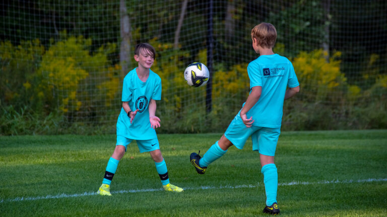 Two youth soccer players playing together.